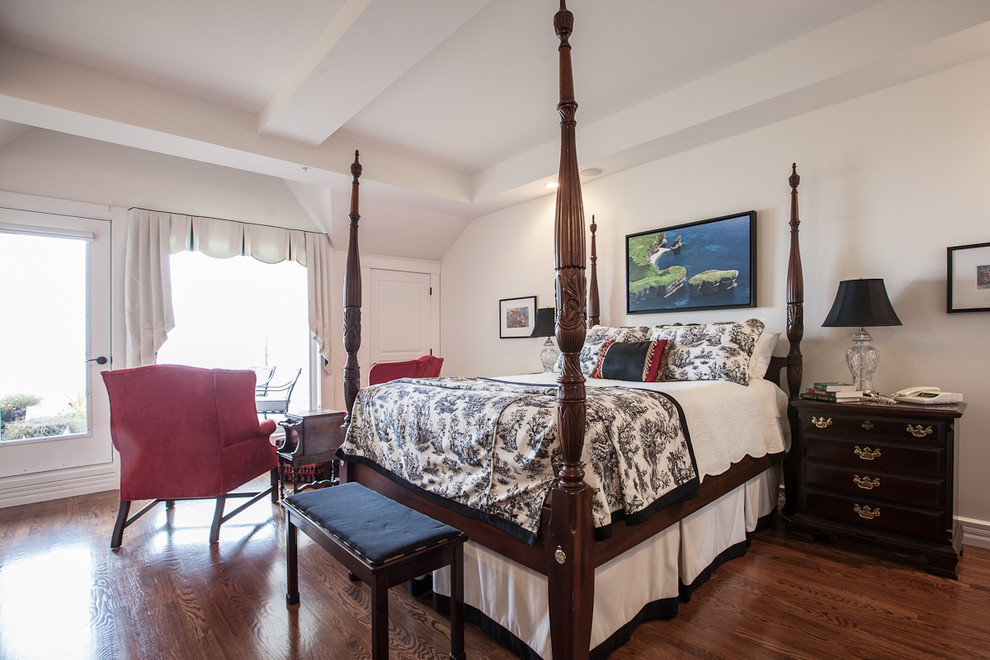 Elegant medium tone wood floor bedroom photo in Other with white walls