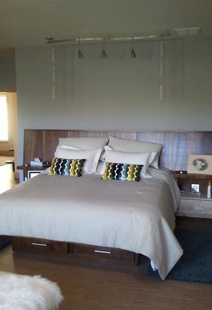 Ejemplo de dormitorio principal moderno de tamaño medio con paredes grises y suelo marrón