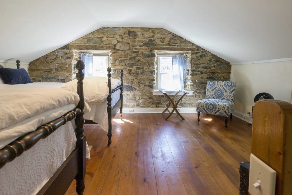 Modelo de habitación de invitados clásica pequeña con paredes negras, suelo de madera en tonos medios, chimenea lineal y suelo marrón