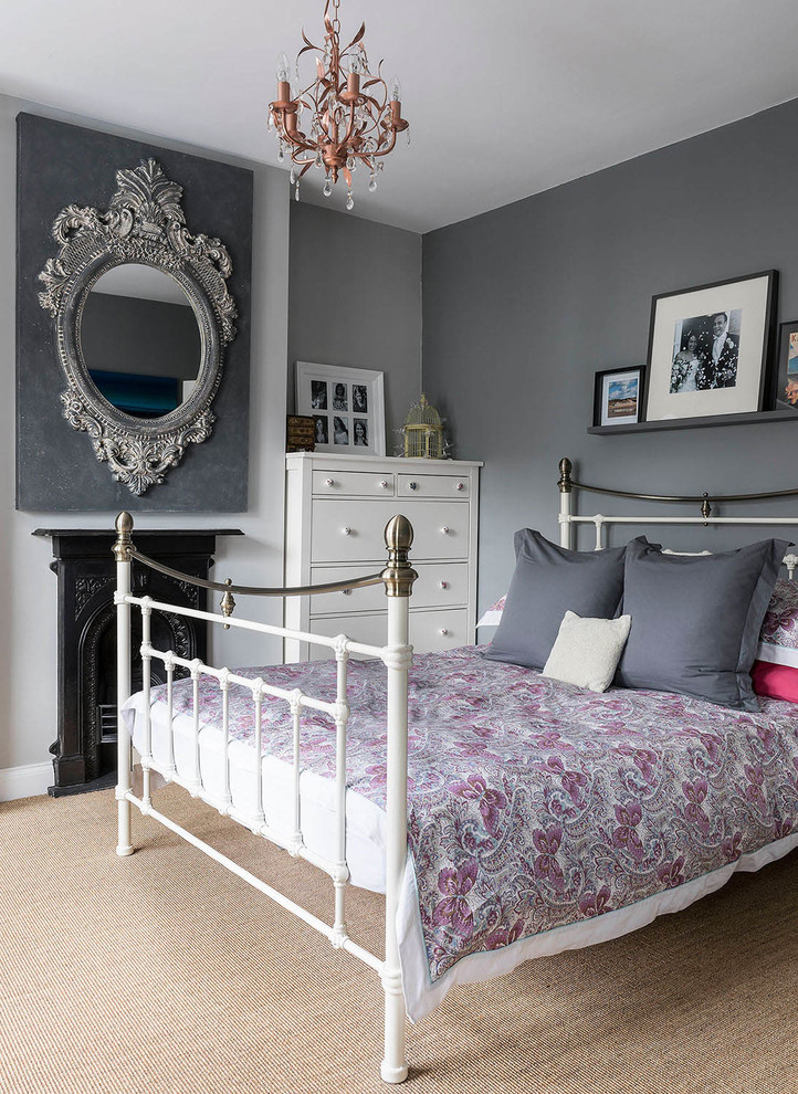 Idée de décoration pour une chambre avec moquette tradition avec un mur gris et une cheminée standard.