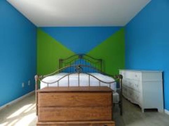 Photo of a small eclectic guest bedroom in Other with blue walls and light hardwood flooring.