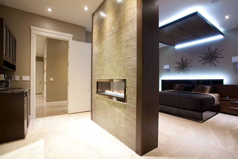 Réalisation d'une chambre design de taille moyenne avec un mur gris, une cheminée double-face et un manteau de cheminée en pierre.