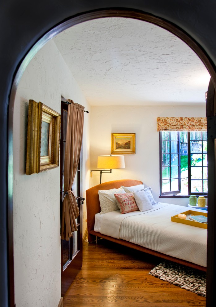 Foto de habitación de invitados mediterránea de tamaño medio sin chimenea con paredes blancas y suelo de madera en tonos medios