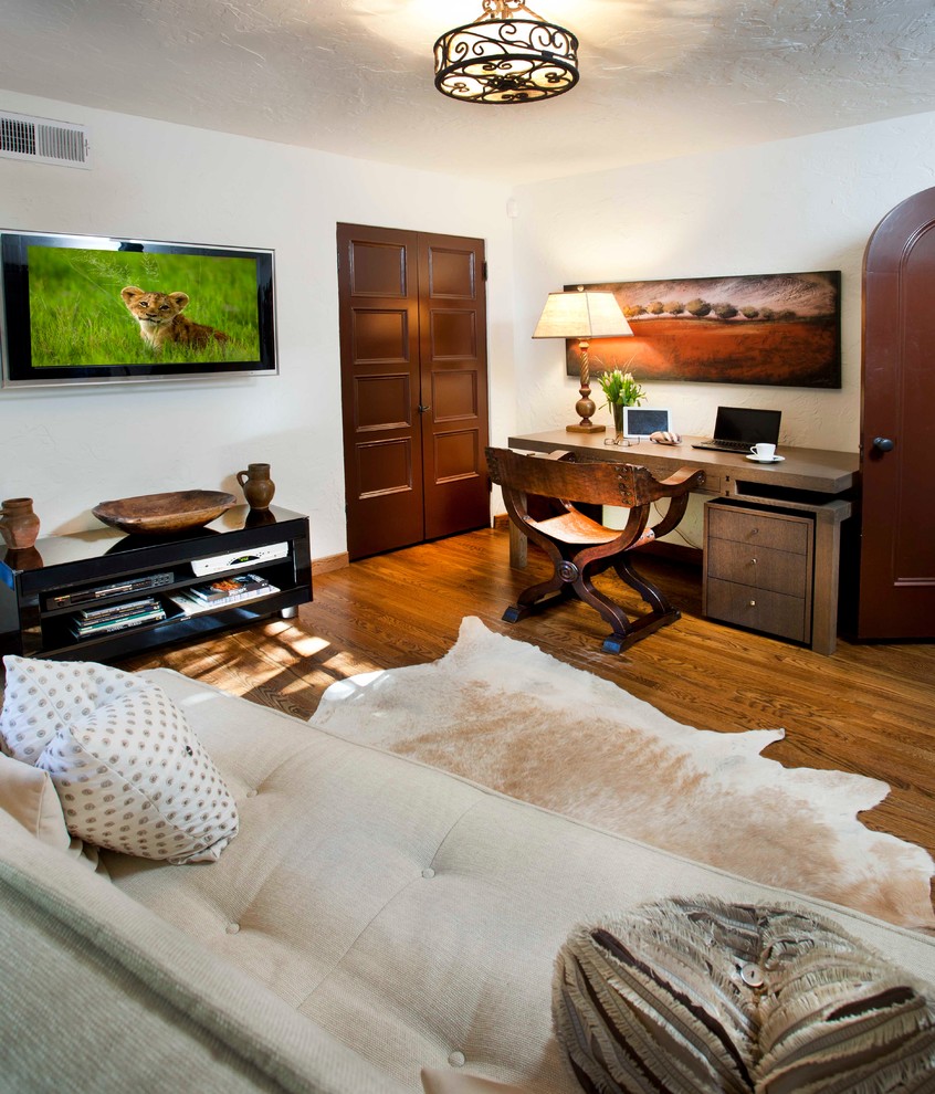На фото: спальня в средиземноморском стиле с белыми стенами и телевизором