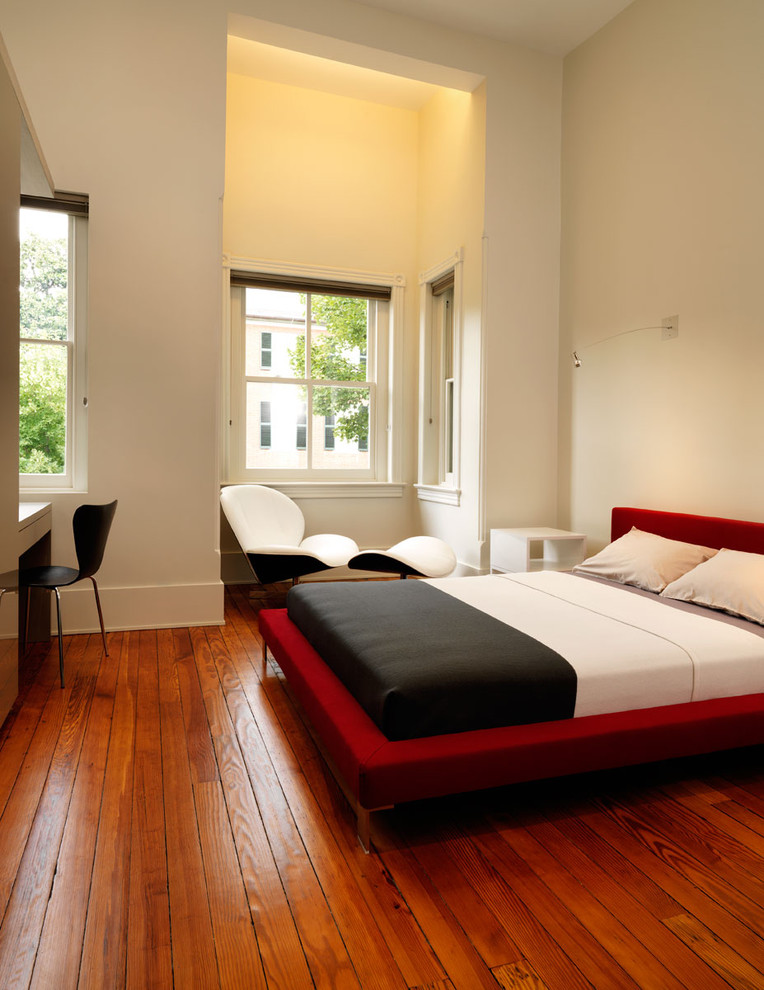 Bild på ett funkis sovrum, med beige väggar, mellanmörkt trägolv och orange golv