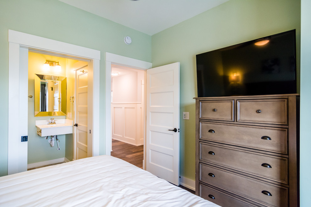他の地域にある中くらいなトランジショナルスタイルのおしゃれな客用寝室 (緑の壁、濃色無垢フローリング、暖炉なし、茶色い床) のインテリア