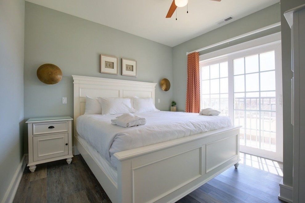 Ejemplo de habitación de invitados costera de tamaño medio sin chimenea con paredes grises, suelo de madera oscura y suelo gris