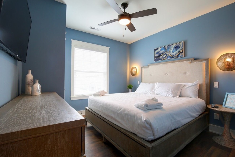Exemple d'une chambre d'amis bord de mer de taille moyenne avec un mur bleu, parquet foncé, aucune cheminée et un sol vert.
