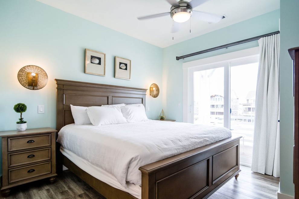This is an example of a small beach style guest bedroom in Other with blue walls, vinyl flooring, no fireplace and brown floors.