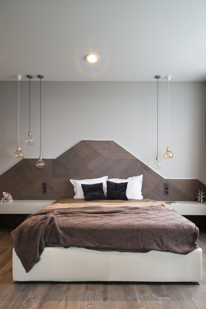 Photo of a contemporary master and grey and brown bedroom in Other with grey walls, dark hardwood flooring, no fireplace and feature lighting.