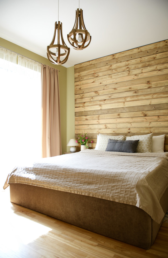 Идея дизайна: спальня в скандинавском стиле с зелеными стенами, светлым паркетным полом и акцентной стеной