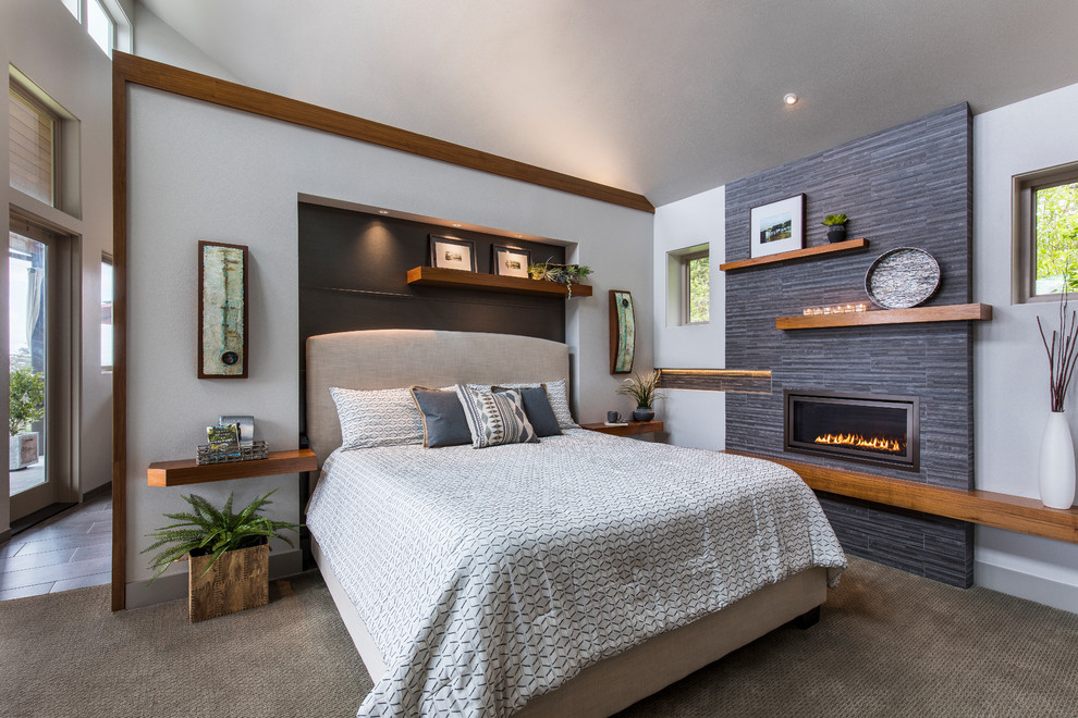 Idée de décoration pour une chambre avec moquette tradition avec un mur gris, une cheminée ribbon, un manteau de cheminée en carrelage et un sol gris.