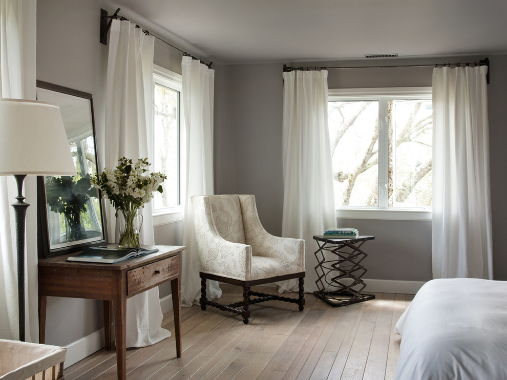 Diseño de habitación de invitados campestre pequeña con paredes grises y suelo de madera clara