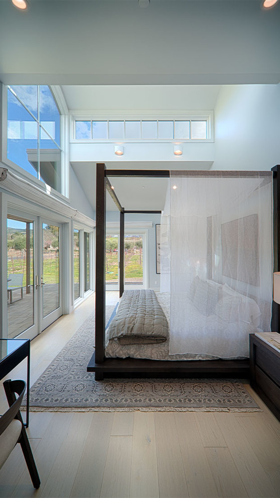 Esempio di una camera da letto country con pareti bianche, parquet chiaro e pavimento beige