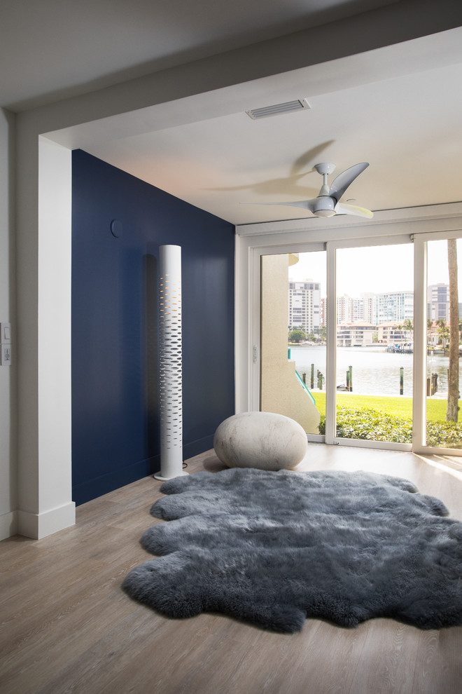 Immagine di una camera degli ospiti minimal di medie dimensioni con pareti blu, pavimento in legno massello medio, nessun camino e pavimento marrone