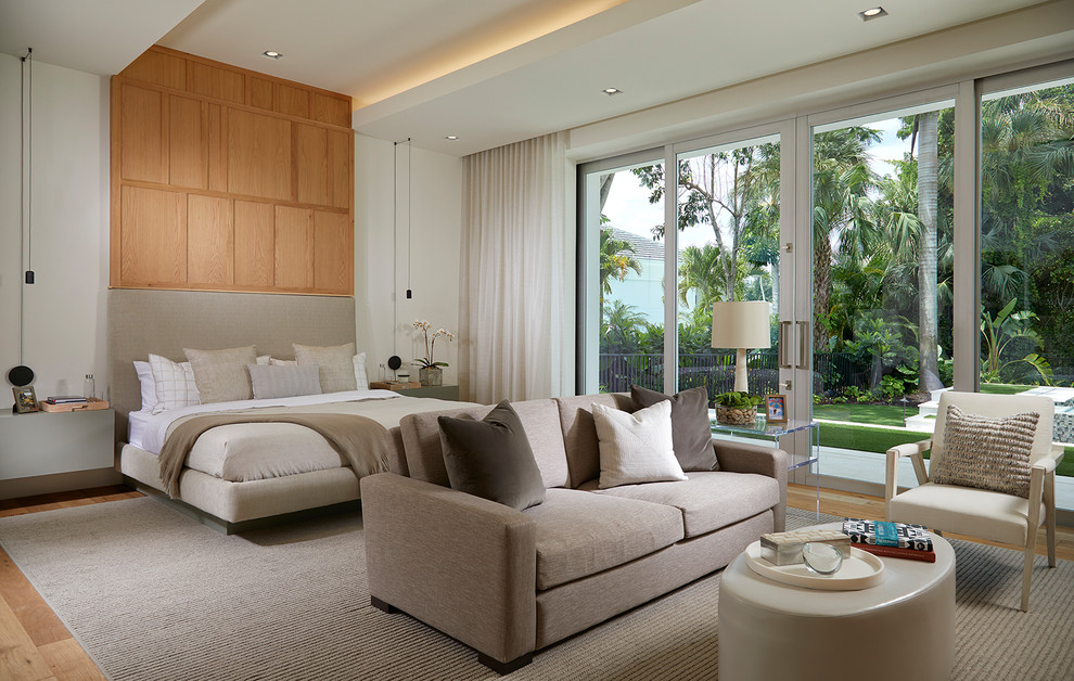 Contemporary master and grey and brown bedroom in Miami with beige walls, medium hardwood flooring and brown floors.