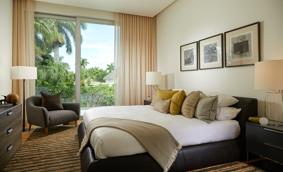 マイアミにあるコンテンポラリースタイルのおしゃれな寝室 (白い壁、無垢フローリング、茶色い床)
