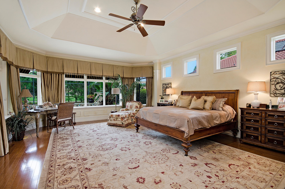 Inspiration for a timeless master medium tone wood floor bedroom remodel in Miami with beige walls