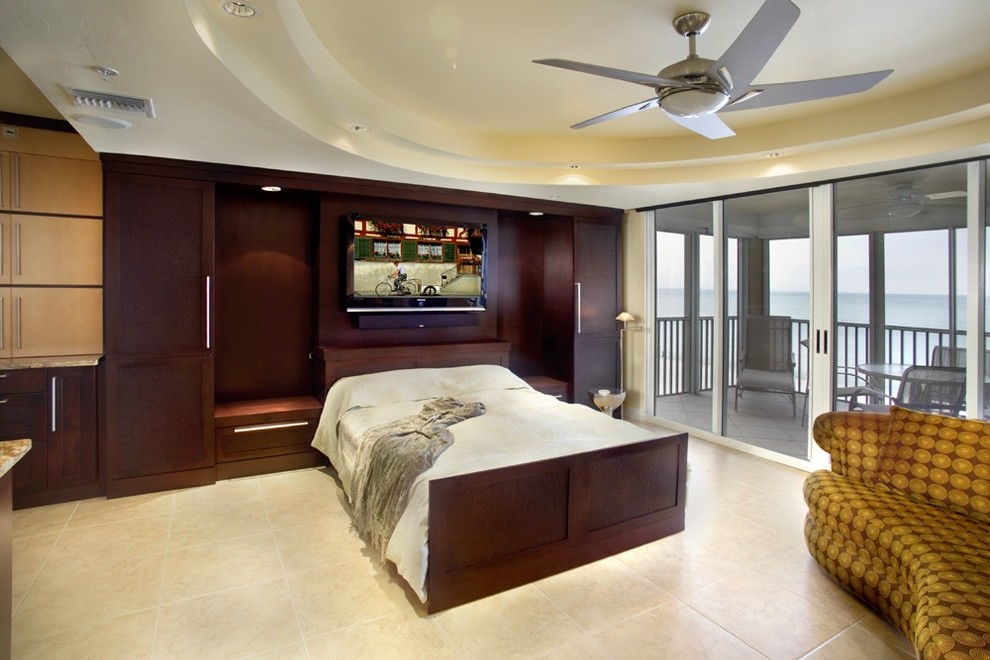 Contemporary bedroom in Miami with beige walls and travertine flooring.