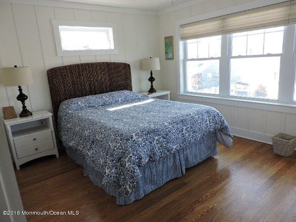 Идея дизайна: гостевая спальня среднего размера, (комната для гостей) в морском стиле с белыми стенами и паркетным полом среднего тона