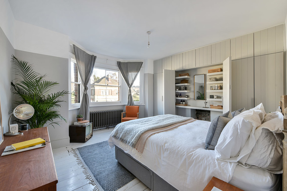 Ejemplo de dormitorio actual de tamaño medio con suelo de madera pintada y suelo blanco