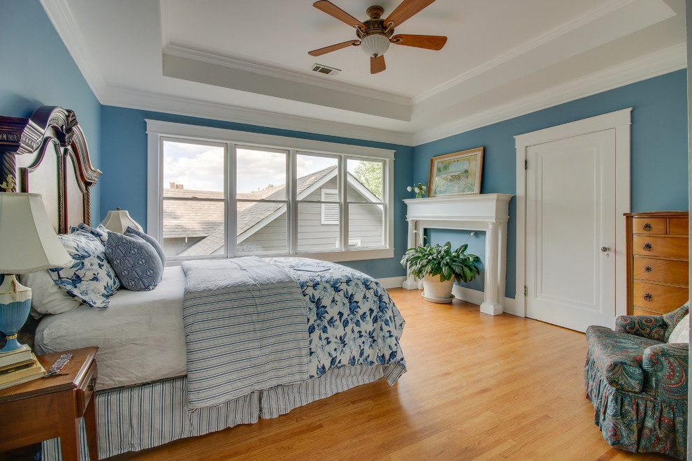 Cette image montre une chambre traditionnelle avec un mur bleu, un sol en bois brun et un sol marron.