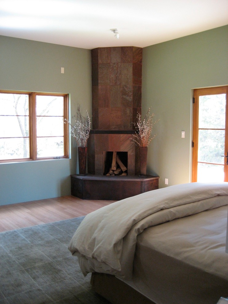Свежая идея для дизайна: хозяйская спальня среднего размера в стиле неоклассика (современная классика) с зелеными стенами, полом из бамбука, угловым камином и фасадом камина из плитки - отличное фото интерьера