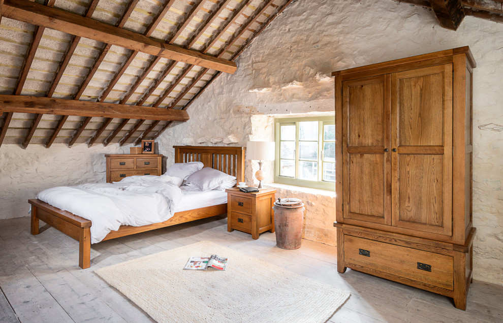 Example of a mid-sized mountain style loft-style light wood floor bedroom design in Other with white walls and no fireplace