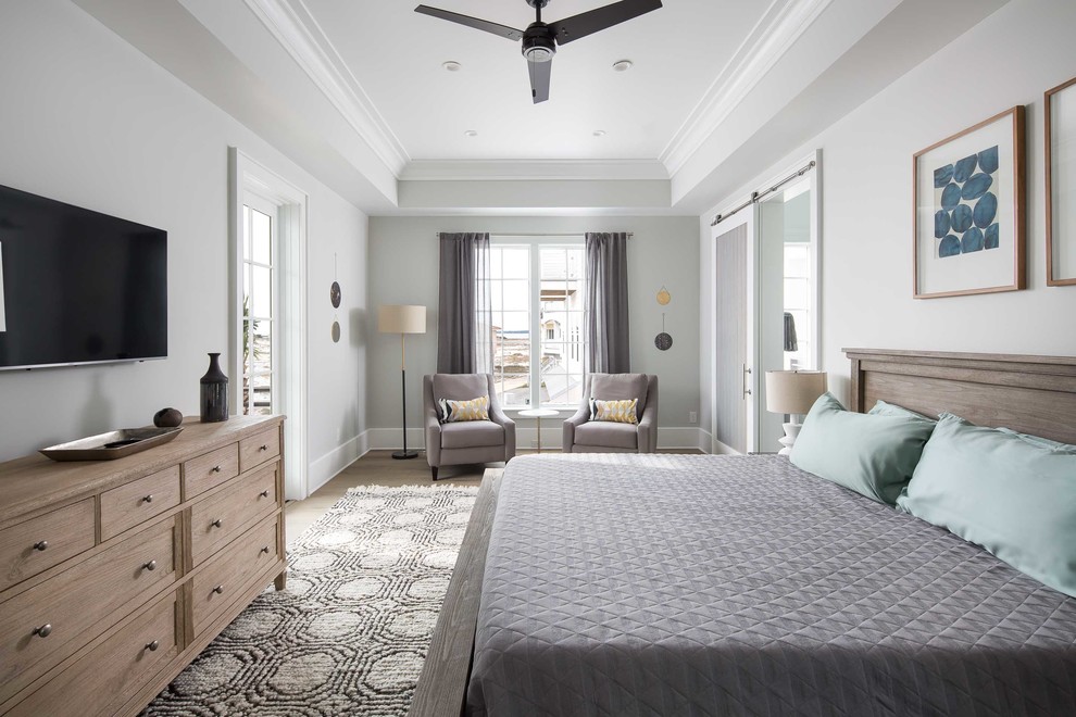 Ejemplo de dormitorio principal marinero grande con paredes grises, suelo de madera clara y suelo marrón