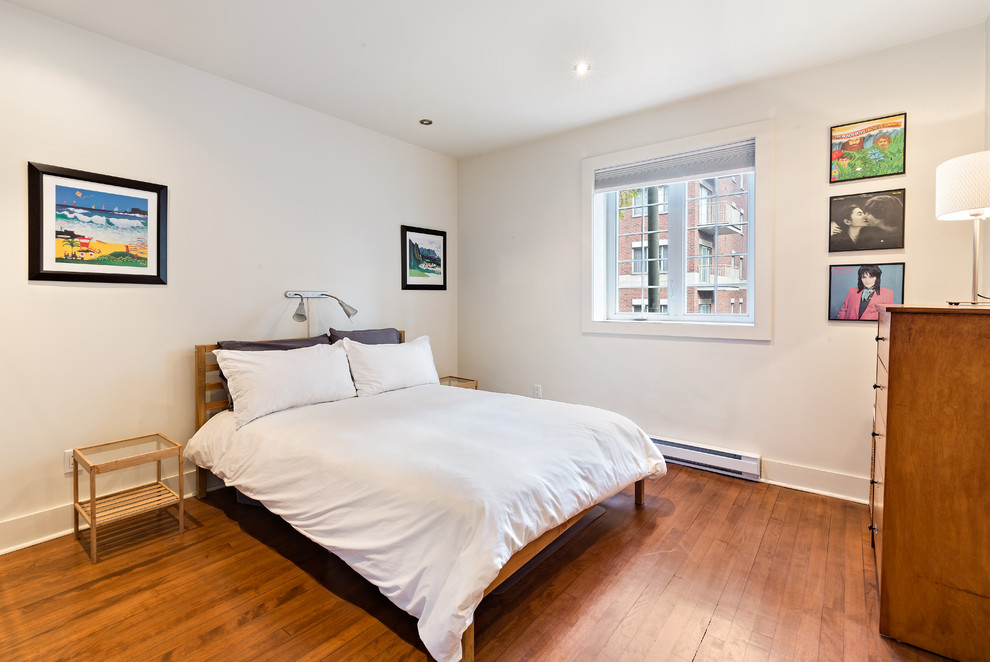 Foto de dormitorio contemporáneo con paredes blancas, suelo de madera en tonos medios y suelo marrón