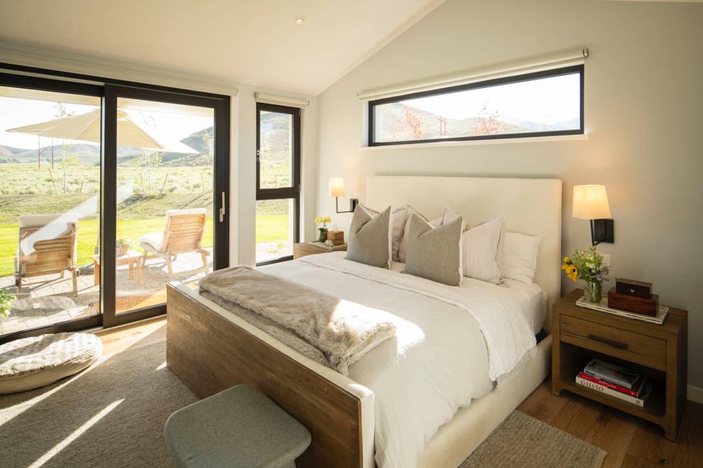 Esempio di una camera da letto country con pareti grigie, pavimento in legno massello medio, pavimento marrone e soffitto a volta