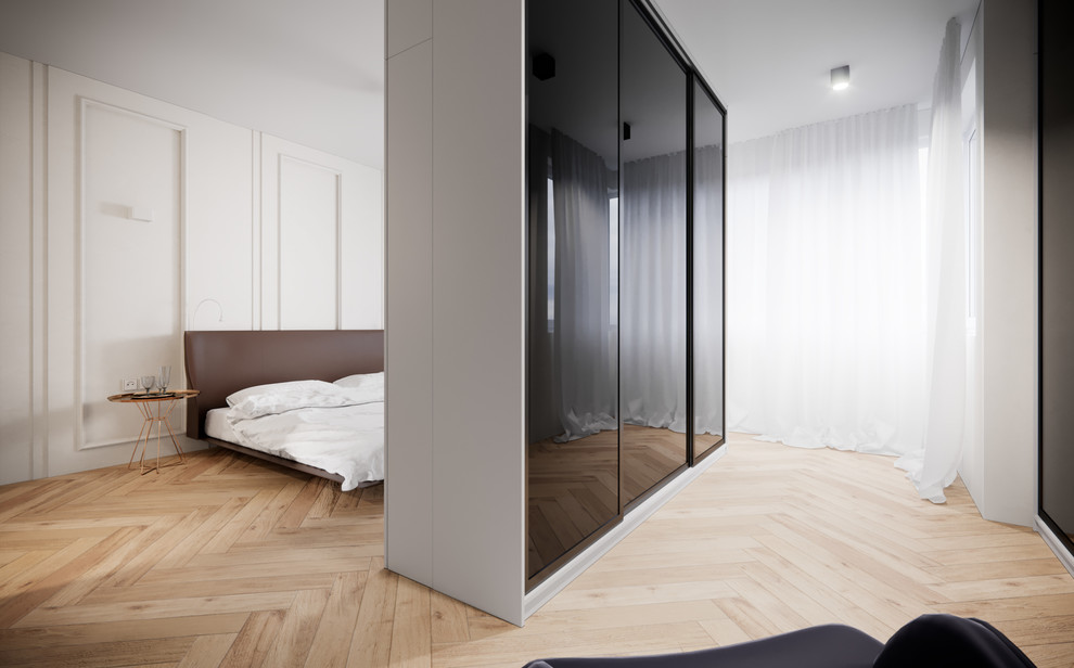 This is an example of a large contemporary master bedroom in London with white walls and light hardwood flooring.