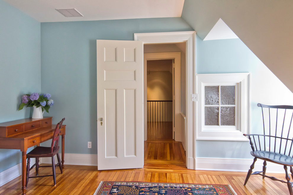 Inspiration for a timeless guest medium tone wood floor bedroom remodel in New York with blue walls