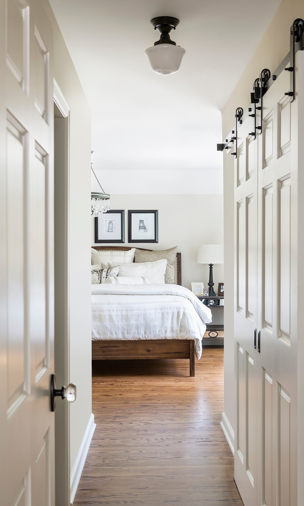 Inspiration for a mid-sized timeless master medium tone wood floor bedroom remodel in Minneapolis with no fireplace and beige walls
