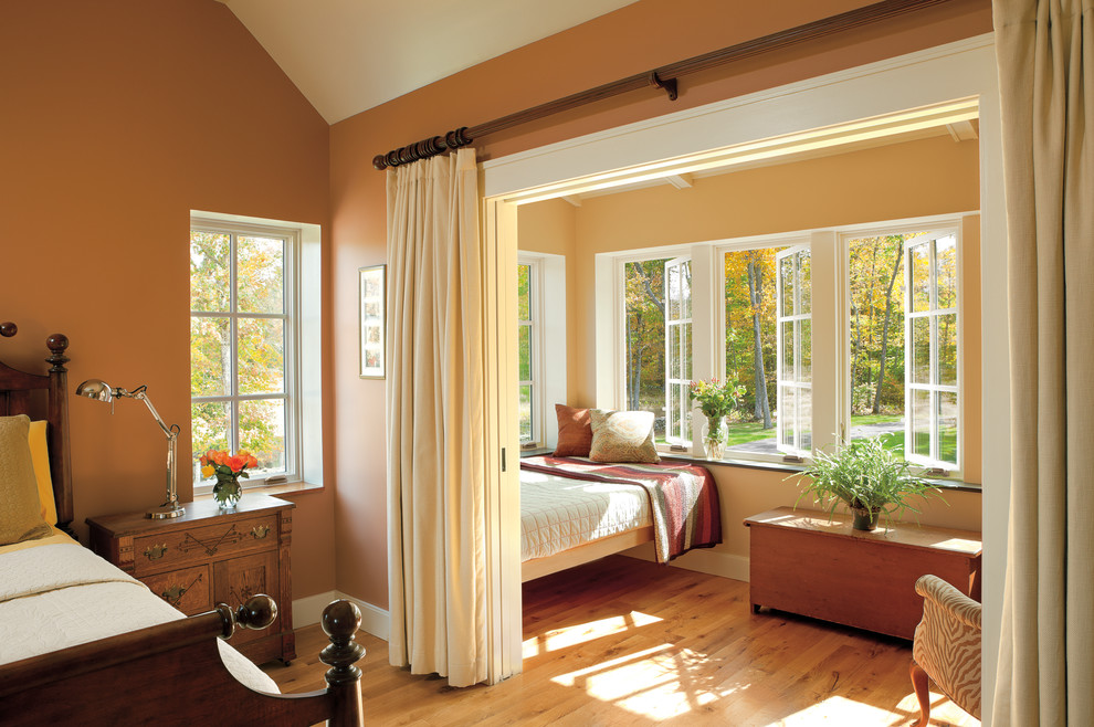 Diseño de habitación de invitados clásica de tamaño medio con parades naranjas y suelo de madera en tonos medios