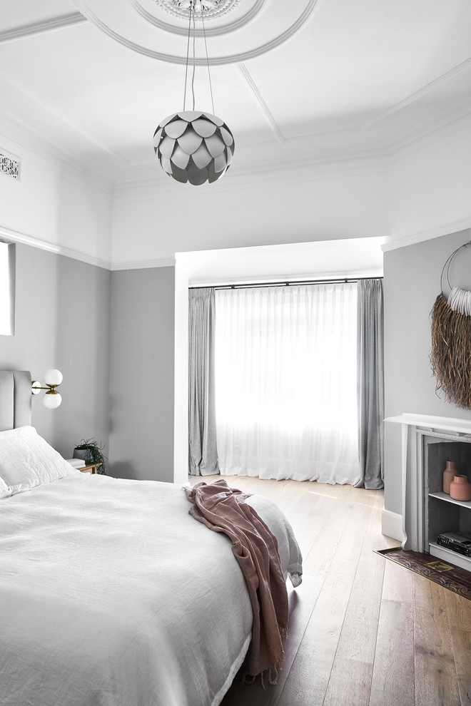 Cette photo montre une chambre tendance de taille moyenne avec un mur gris, parquet clair et un sol beige.