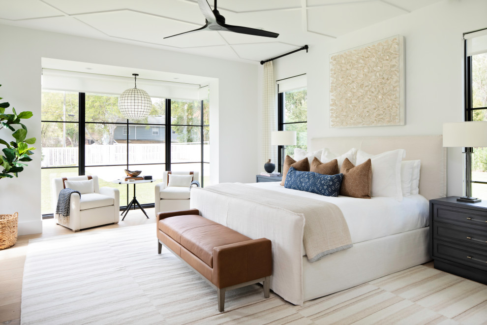 Photo of a large classic master bedroom in Orlando with white walls, light hardwood flooring and beige floors.