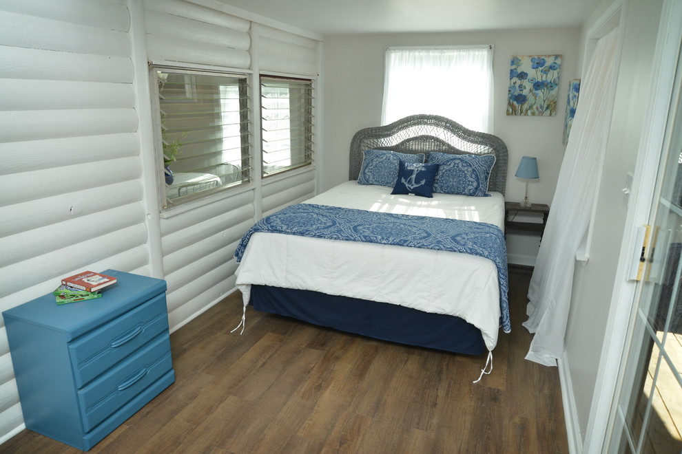Bedroom - small cottage guest vinyl floor and brown floor bedroom idea in Other with white walls