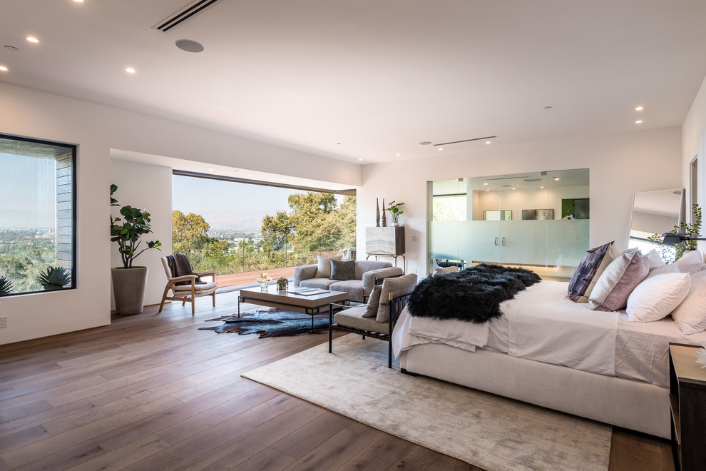 Bedroom - huge contemporary master medium tone wood floor and brown floor bedroom idea in Los Angeles with white walls