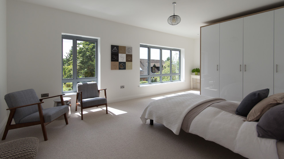 Design ideas for a large modern guest bedroom in London with white walls, carpet and beige floors.