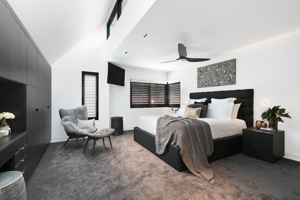 This is an example of a medium sized contemporary master bedroom in Sydney with white walls, carpet and grey floors.