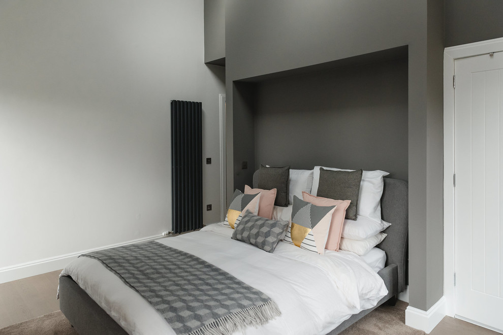 Contemporary grey and brown bedroom in Glasgow with white walls and brown floors.