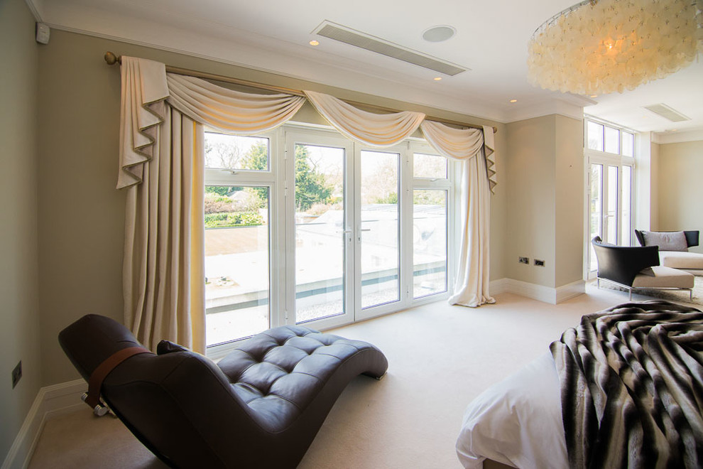 This is an example of a large contemporary master bedroom in London with grey walls and carpet.