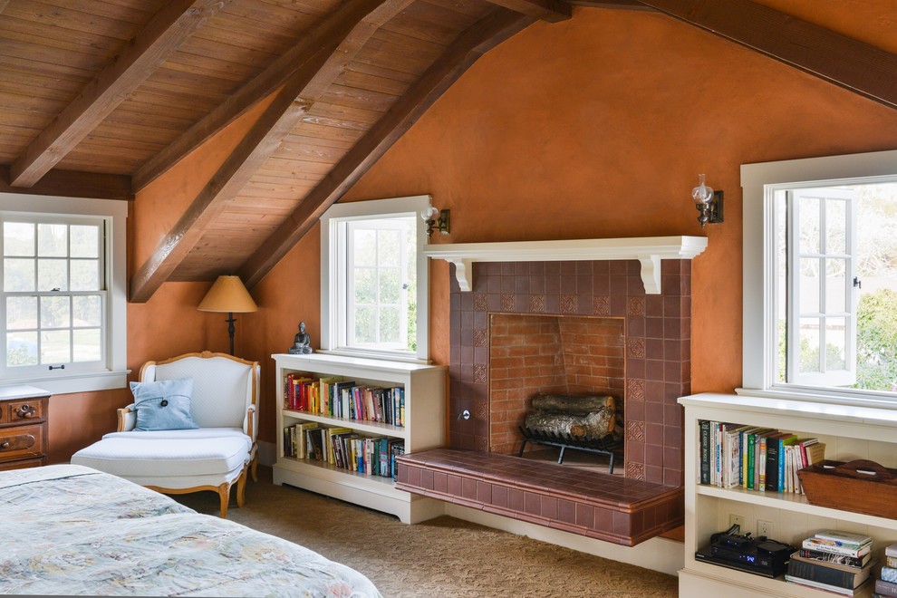 На фото: спальня в стиле кантри с оранжевыми стенами, ковровым покрытием, стандартным камином и фасадом камина из плитки с