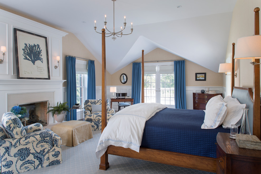 На фото: спальня в классическом стиле с бежевыми стенами, стандартным камином и синими шторами с