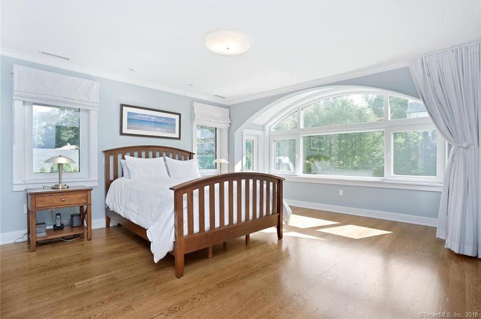 Aménagement d'une chambre parentale classique de taille moyenne avec un mur bleu, parquet clair et un sol beige.