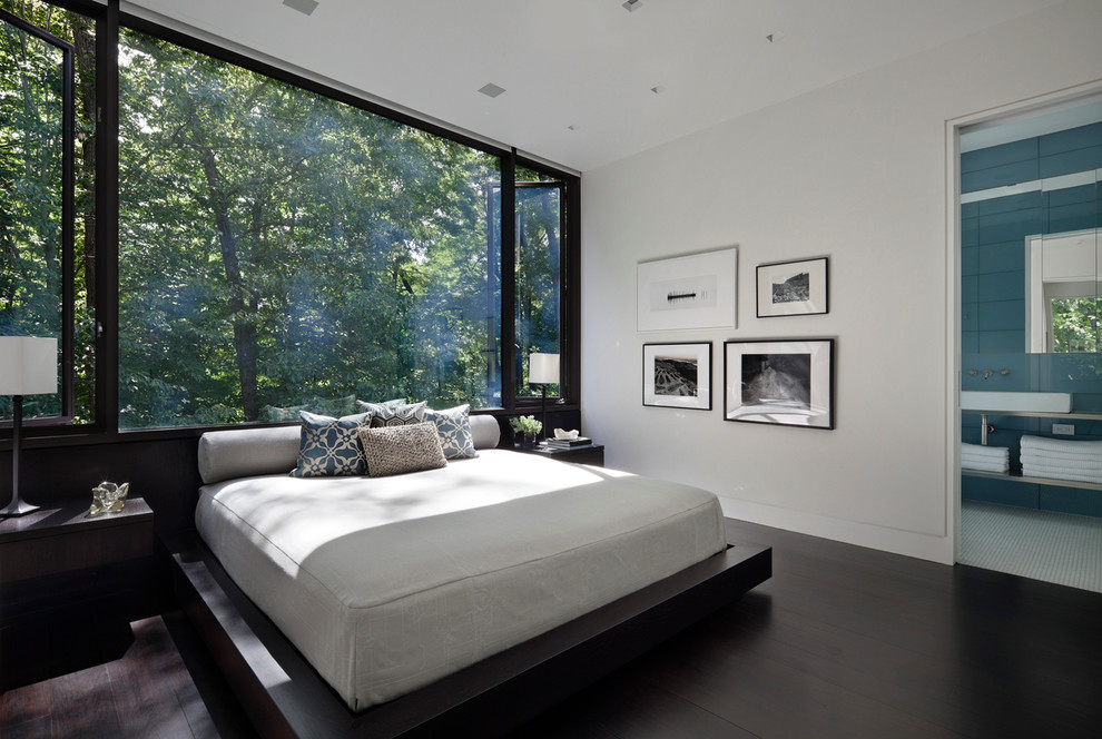 Large minimalist dark wood floor and brown floor bedroom photo in New York with white walls