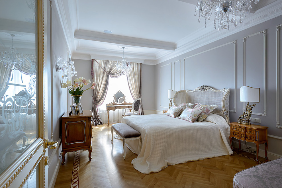 Diseño de dormitorio principal tradicional grande sin chimenea con paredes grises y suelo de madera clara