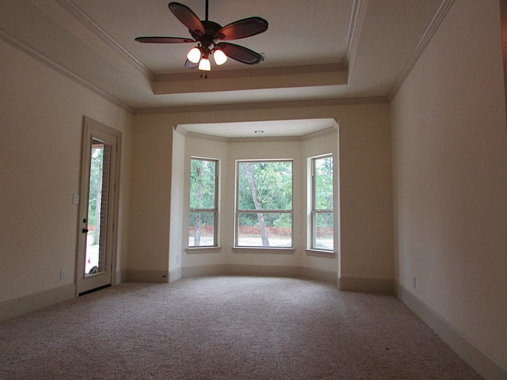 Design ideas for a large traditional master bedroom in Houston with beige walls, carpet, no fireplace and beige floors.