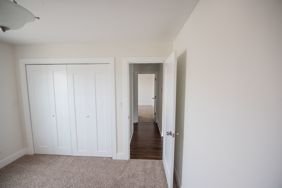 Foto di una piccola camera da letto stile loft design con pareti bianche, moquette e pavimento marrone